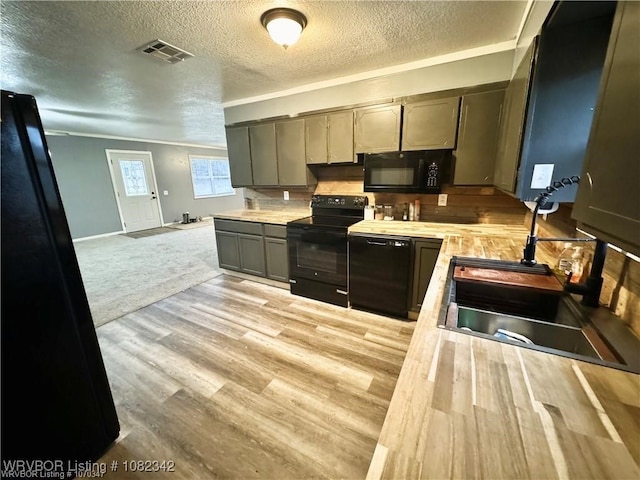 39668 S Barton, Fanshawe, OK 74935 - kitchen with black appliances, light countertops, light wood finished floors, a textured ceiling, and ornamental molding