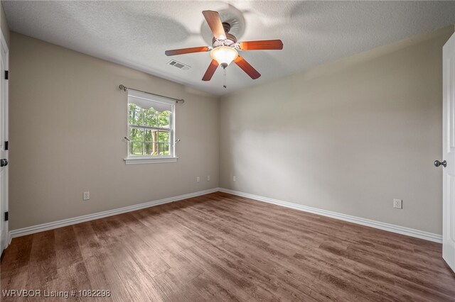 6721 Dean Rd, Alma, AR 72921 - spare room featuring wood finished floors, a ceiling fan, and a textured ceiling