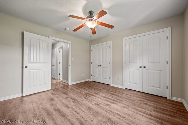 6721 Dean Rd, Alma, AR 72921 - unfurnished bedroom with wood finished floors, two closets, and ceiling fan