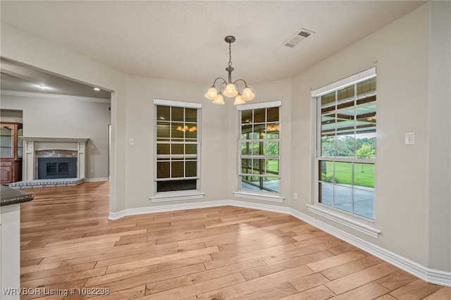 6721 Dean Rd, Alma, AR 72921 - unfurnished dining area featuring a chandelier, light wood finished floors, a glass covered fireplace, and crown molding
