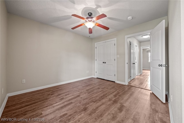 6721 Dean Rd, Alma, AR 72921 - unfurnished bedroom with wood finished floors, a ceiling fan, and a textured ceiling
