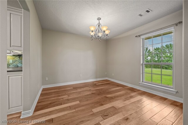 6721 Dean Rd, Alma, AR 72921 - spare room with light wood finished floors, plenty of natural light, a chandelier, and a textured ceiling