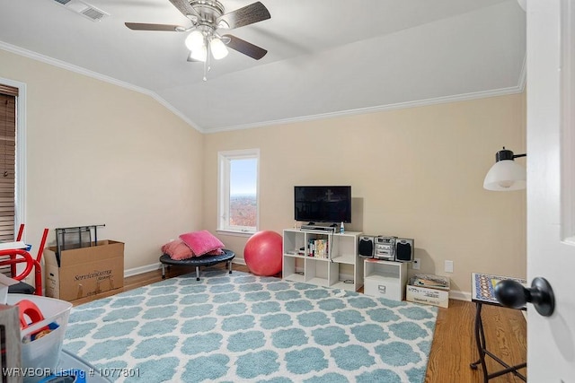 bedroom with wood finished floors, visible vents, baseboards, ornamental molding, and lofted ceiling