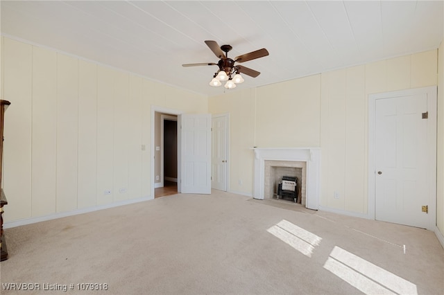 unfurnished living room featuring ceiling fan, carpet, and a fireplace with flush hearth