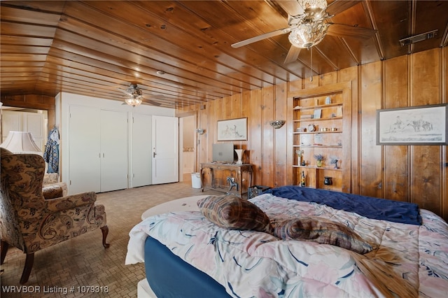 carpeted bedroom featuring wooden ceiling, visible vents, ceiling fan, and wooden walls
