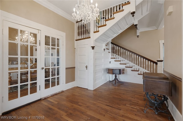 entrance foyer featuring crown molding, wood finished floors, french doors, stairway, and an inviting chandelier
