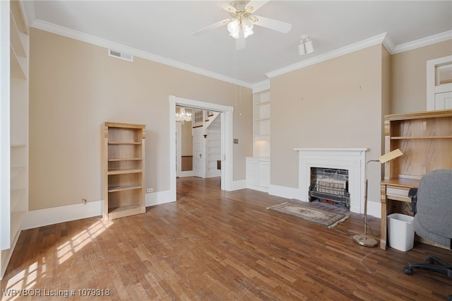 unfurnished living room with visible vents, wood finished floors, crown molding, built in shelves, and a fireplace