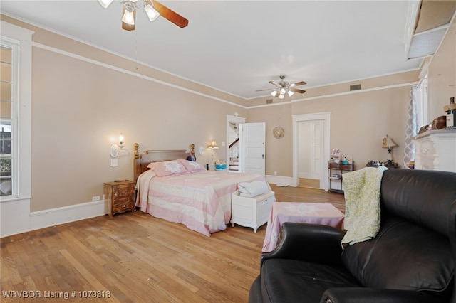 bedroom featuring light wood-type flooring, visible vents, and ornamental molding