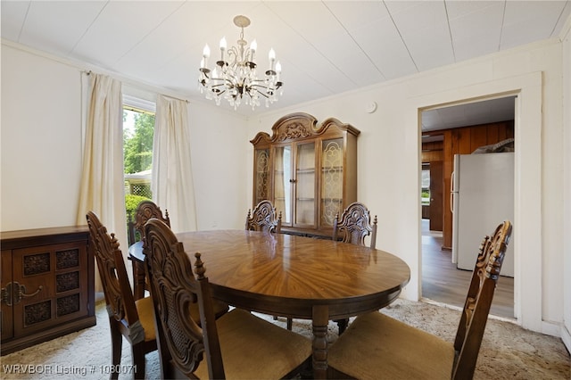 dining area with ornamental molding, light colored carpet, and an inviting chandelier