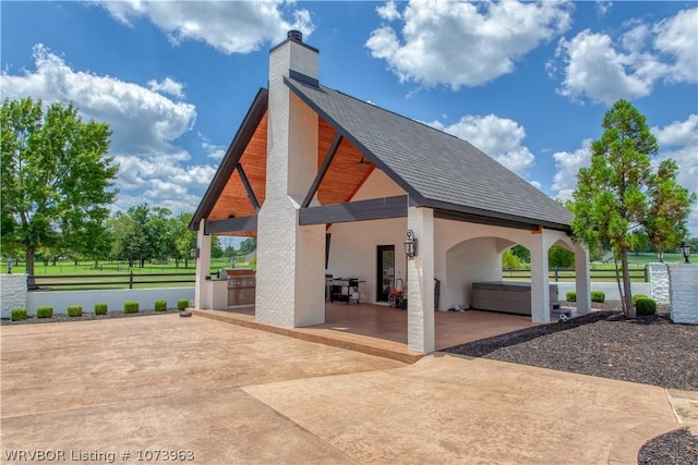 view of patio with a hot tub and exterior kitchen