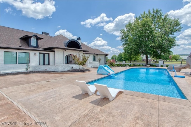 view of pool featuring a patio and a water slide