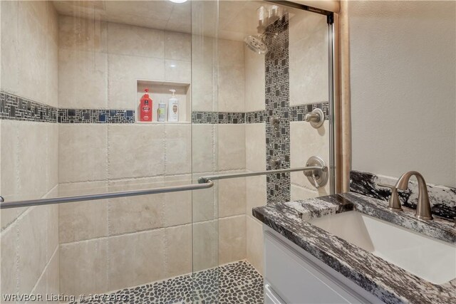 bathroom with vanity and a shower with shower door