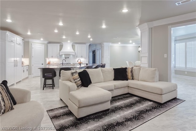 living room featuring ornamental molding and sink