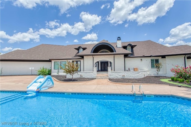 view of pool with a patio area and a water slide