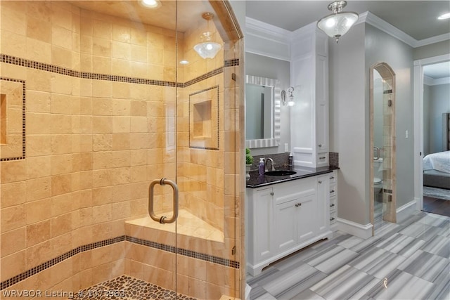 bathroom with toilet, a shower with door, vanity, and ornamental molding