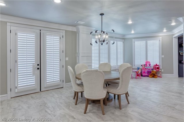 dining area with ornamental molding and an inviting chandelier