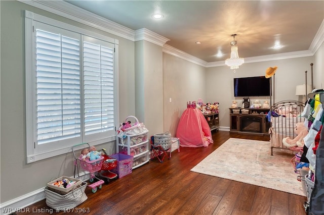 recreation room with crown molding, dark hardwood / wood-style flooring, and a notable chandelier