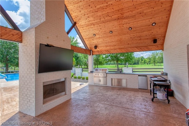 view of patio / terrace with a fenced in pool, area for grilling, an outdoor kitchen, and exterior fireplace