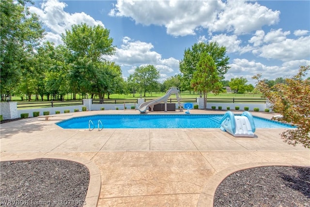 view of swimming pool with a patio area and a water slide