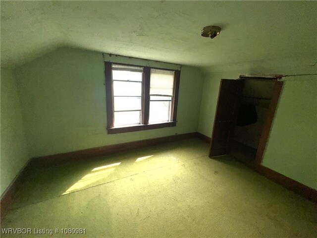 1221 S 3rd St, Stilwell, OK 74960 - additional living space featuring vaulted ceiling, baseboards, and light colored carpet