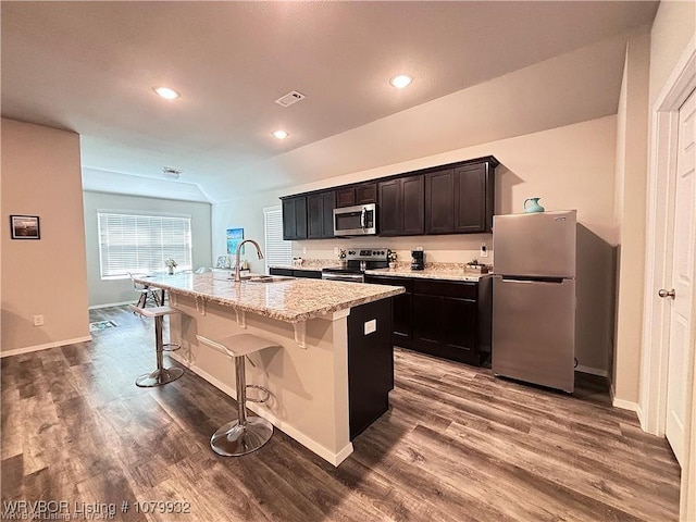 kitchen featuring a sink, a kitchen island with sink, appliances with stainless steel finishes, and dark wood-type flooring