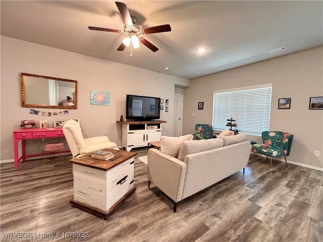 living area featuring baseboards, dark wood-style flooring, visible vents, and a ceiling fan