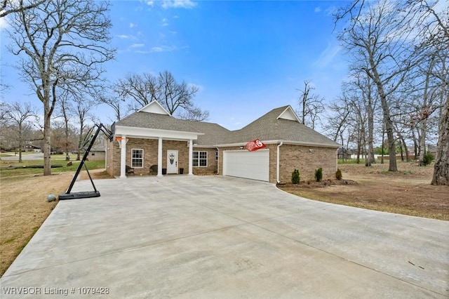 1111 Ridge Dr, Stilwell, OK 74960 - view of front of house featuring roof with shingles, an attached garage, brick siding, and concrete driveway