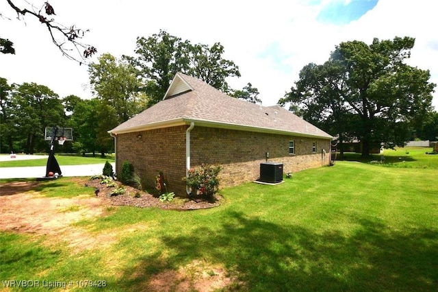 1111 Ridge Dr, Stilwell, OK 74960 - view of property exterior with a yard, central air condition unit, brick siding, and a shingled roof