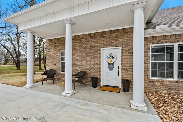1111 Ridge Dr, Stilwell, OK 74960 - doorway to property featuring a shingled roof and brick siding