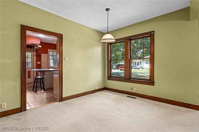 carpeted empty room featuring a textured ceiling