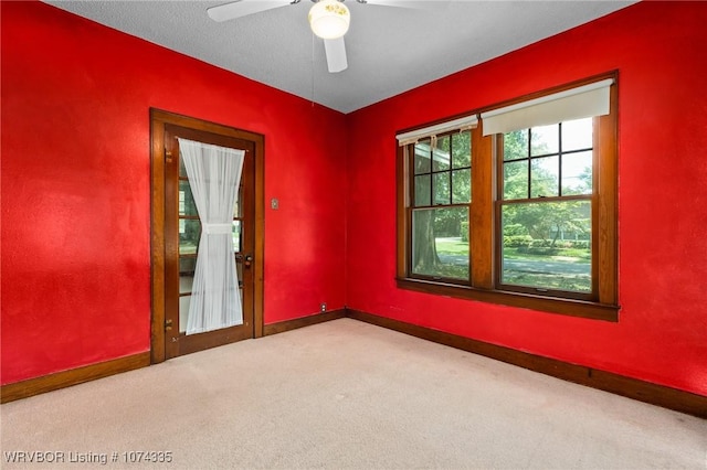 unfurnished room with light carpet, a textured ceiling, and ceiling fan