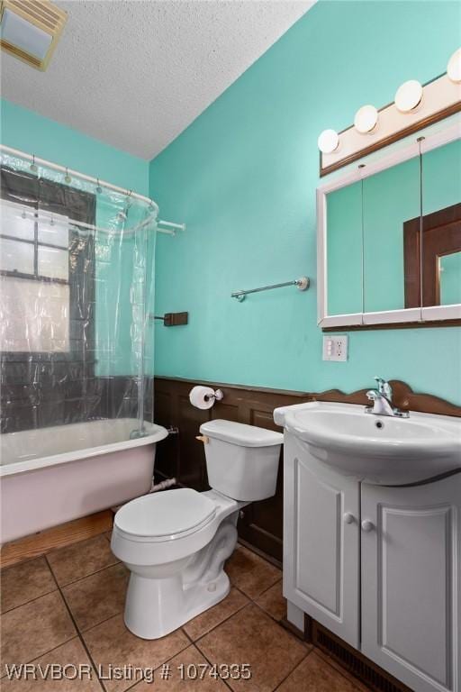 full bathroom featuring vanity, shower / bath combination with curtain, a textured ceiling, tile patterned floors, and toilet