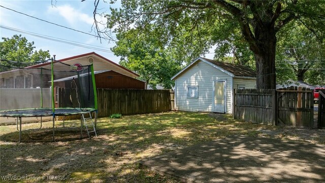 view of yard featuring an outdoor structure and a trampoline