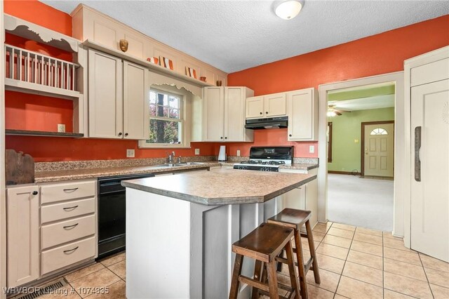 kitchen featuring a kitchen breakfast bar, a center island, black appliances, a textured ceiling, and light tile patterned flooring