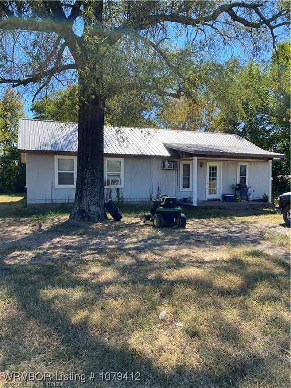 ranch-style house with metal roof and a front yard