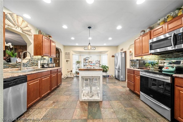 kitchen with sink, stainless steel appliances, hanging light fixtures, and tasteful backsplash