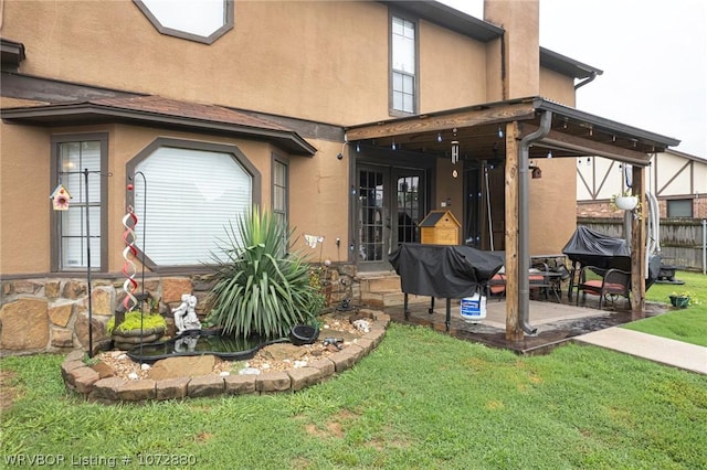 rear view of property with french doors, a patio area, and a lawn