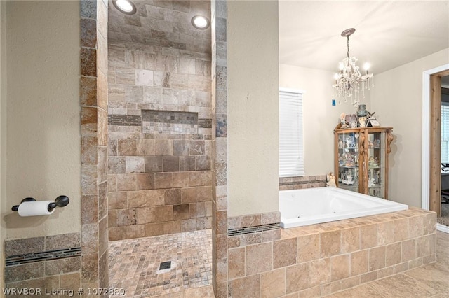 bathroom featuring a chandelier and separate shower and tub