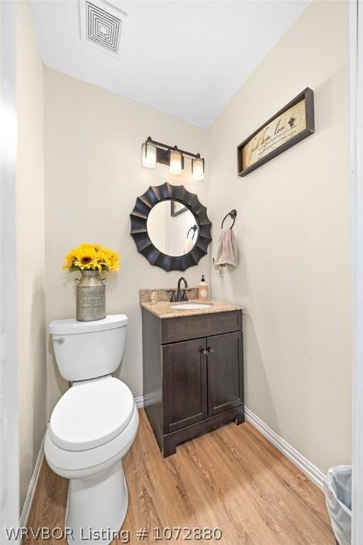 bathroom featuring hardwood / wood-style floors, vanity, and toilet