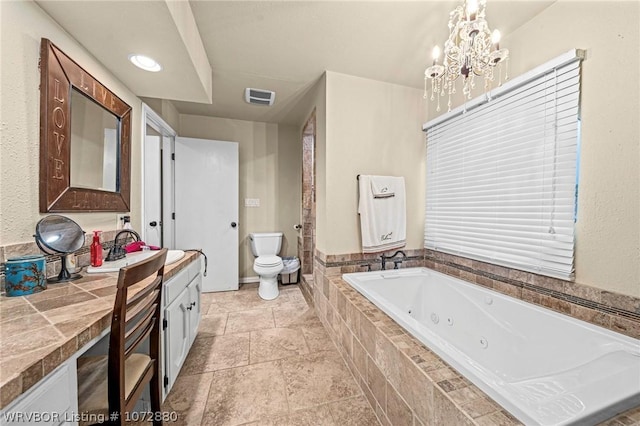 bathroom featuring vanity, a relaxing tiled tub, a chandelier, and toilet