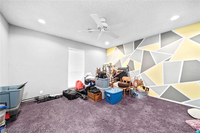 recreation room featuring ceiling fan, carpet floors, and a textured ceiling