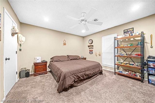 bedroom with ceiling fan, carpet floors, and a textured ceiling