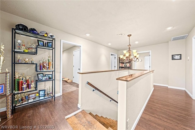 interior space with pendant lighting, dark hardwood / wood-style floors, and an inviting chandelier