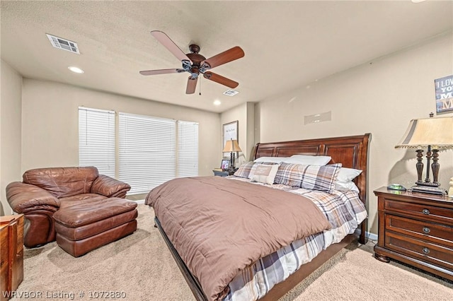 bedroom with ceiling fan, a textured ceiling, and light carpet