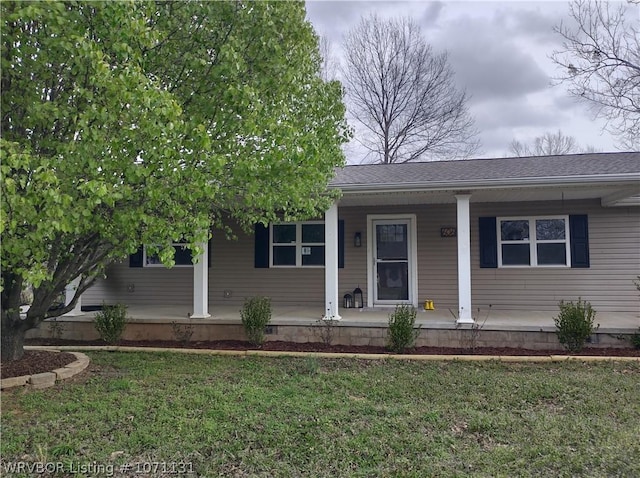 ranch-style house featuring covered porch and a front yard