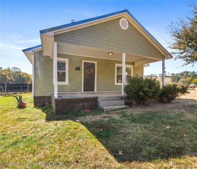 bungalow-style house featuring covered porch and a front lawn