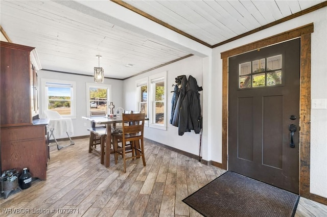 dining space with crown molding, a wealth of natural light, light hardwood / wood-style flooring, and wood ceiling