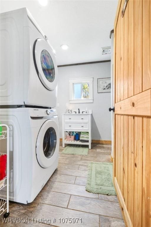 laundry area featuring light hardwood / wood-style flooring and stacked washer and clothes dryer