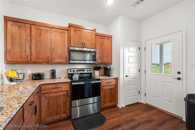 112 Countryside Way, Pocola, OK 74902 - kitchen with appliances with stainless steel finishes, dark wood-type flooring, brown cabinets, decorative backsplash, and light stone counters