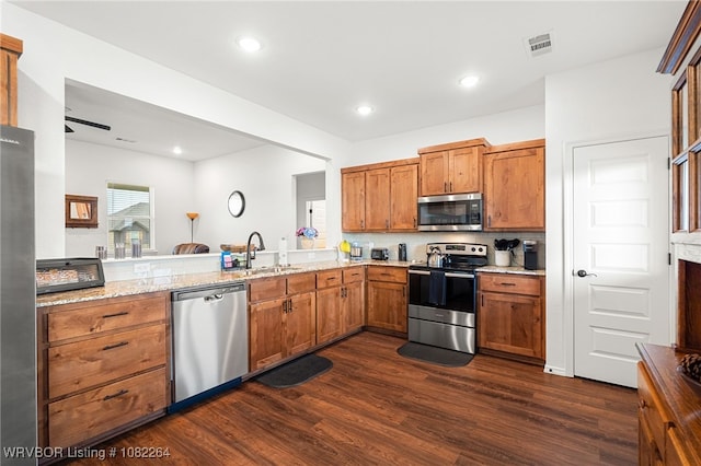 112 Countryside Way, Pocola, OK 74902 - kitchen featuring appliances with stainless steel finishes, dark wood-style flooring, brown cabinets, light stone countertops, and recessed lighting